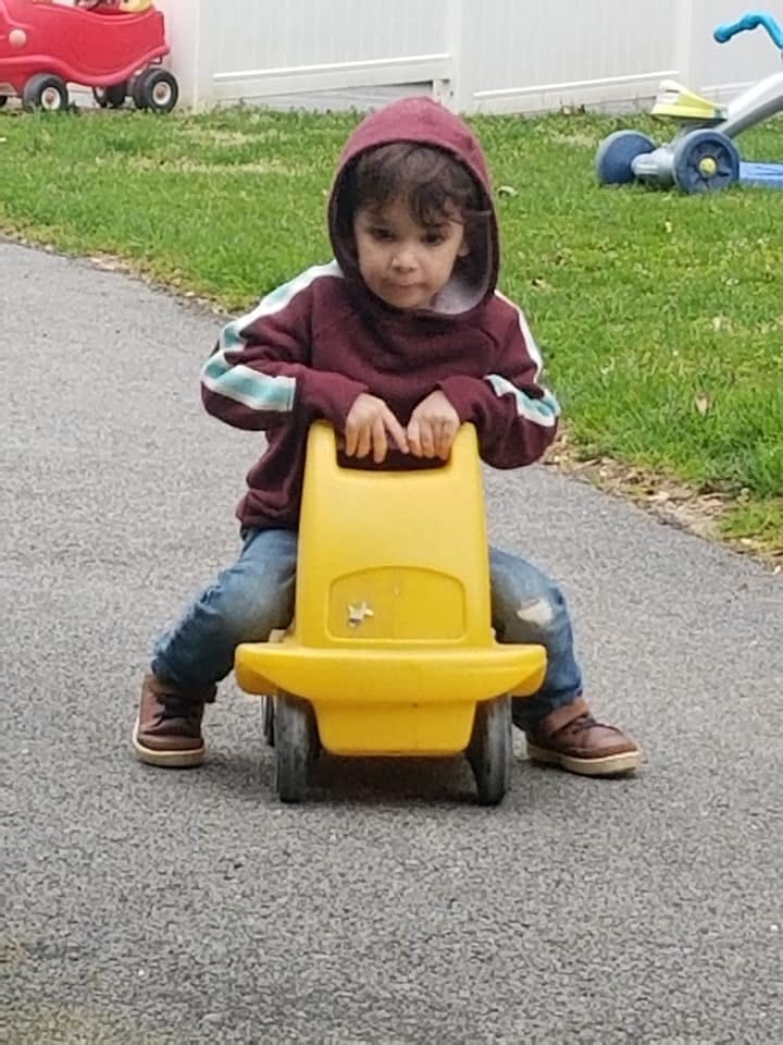 Child sitting on a yellow ride-on toy