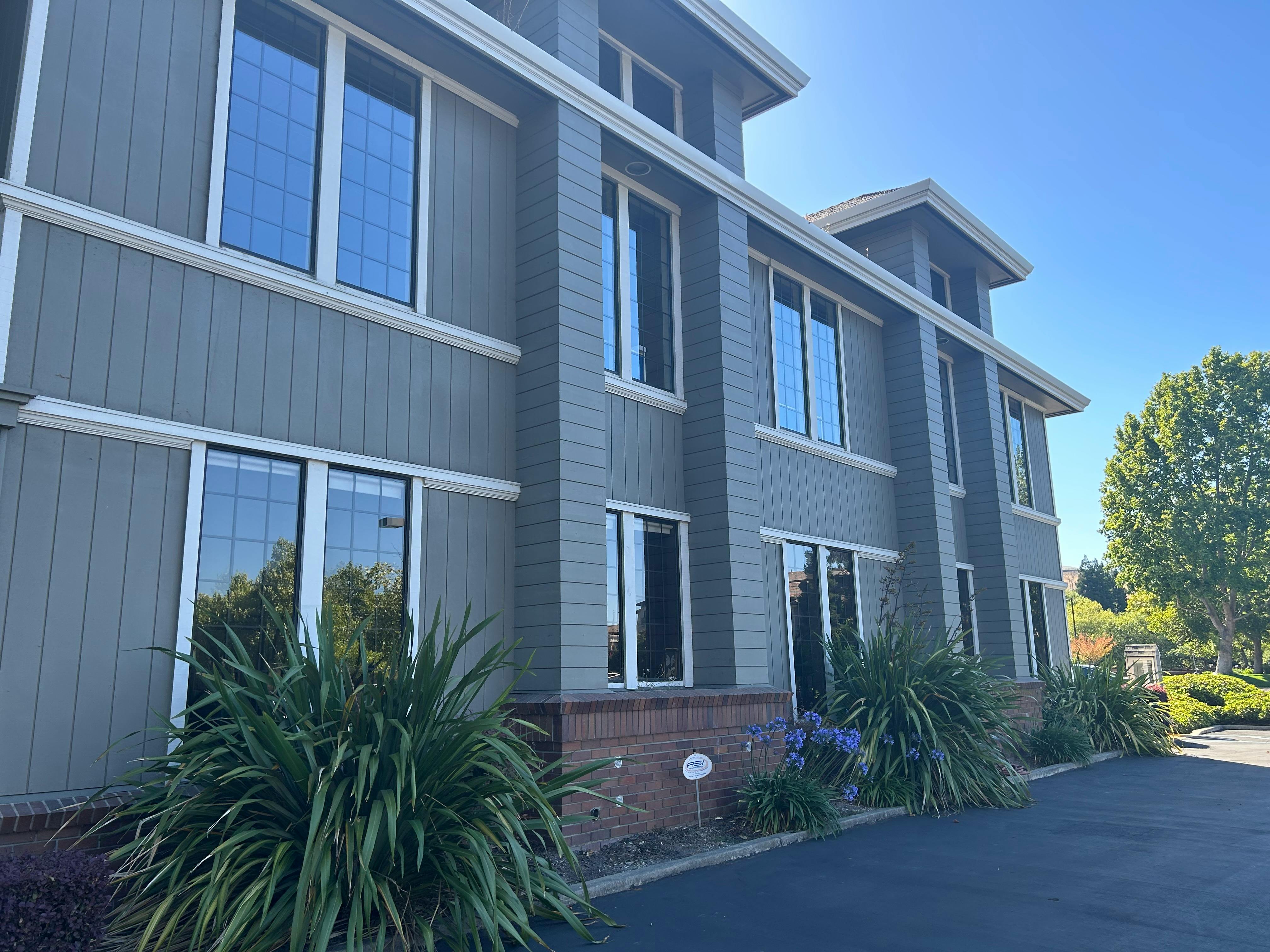 Exterior of a multi-story building with gray siding and white trim