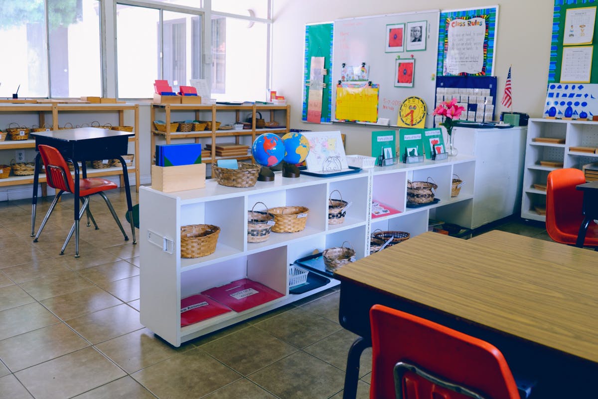 Classroom with desks, chairs, and shelves with learning materials