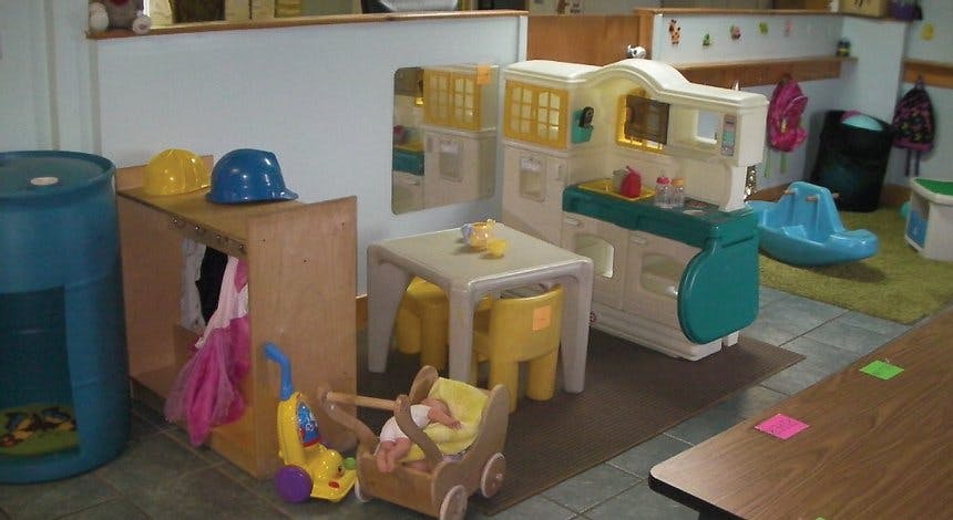 Playroom with toy kitchen, table, chairs, and other toys