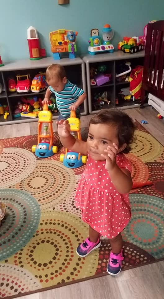 Two children playing with toys on a colorful rug