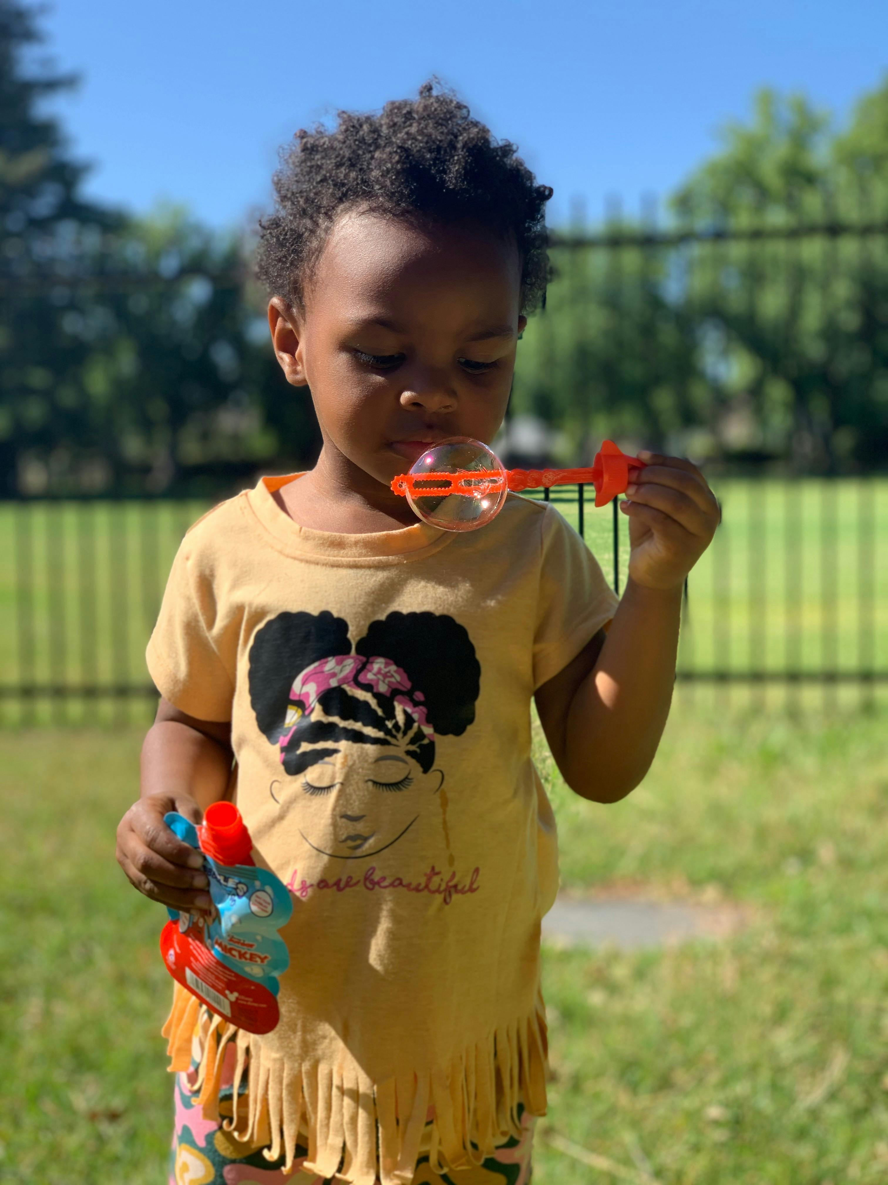 Child blowing bubbles outdoors