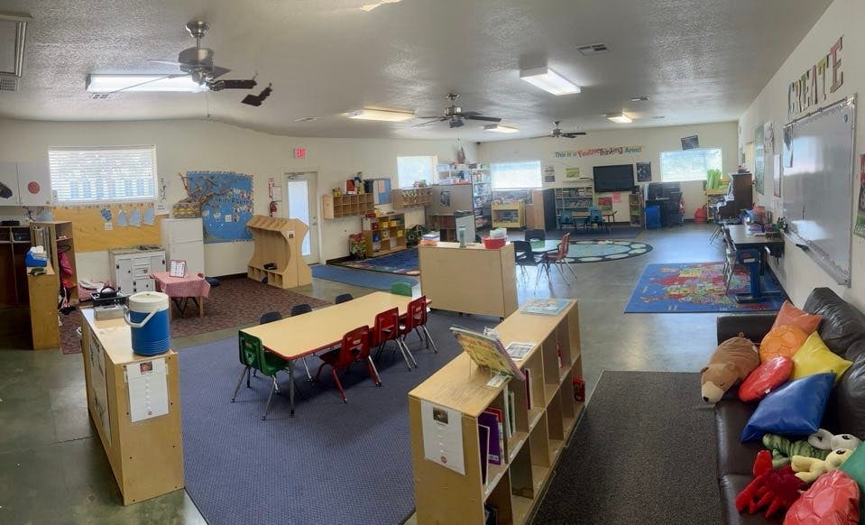 Classroom with tables, chairs, and play areas