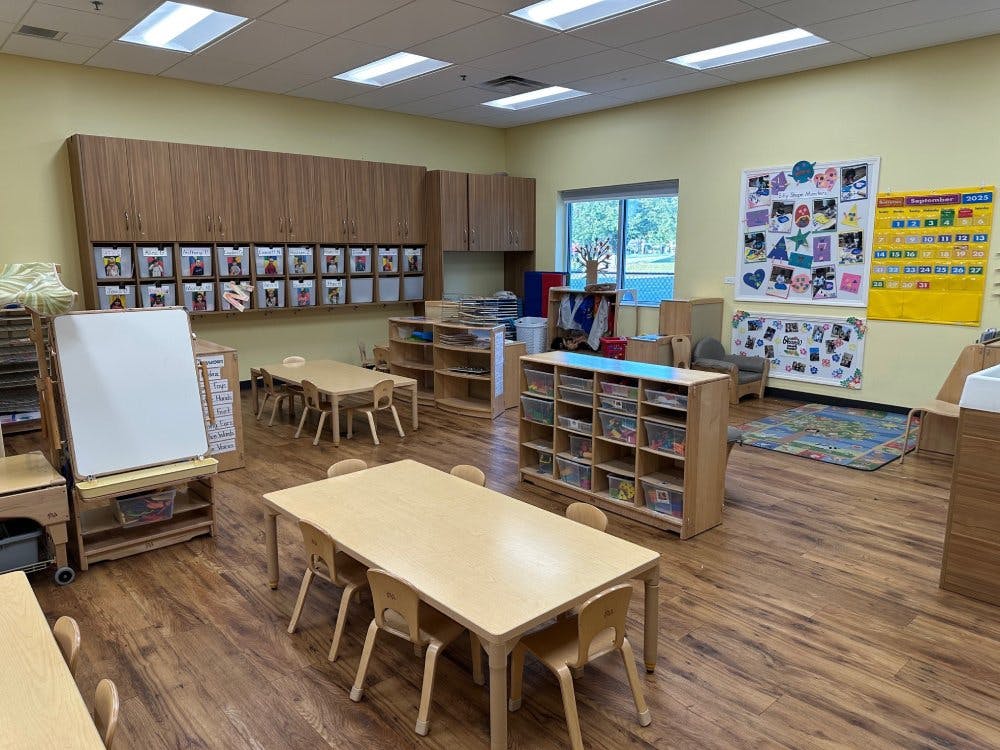 Classroom with small tables, chairs, cabinets, a whiteboard, and a September 2025 calendar