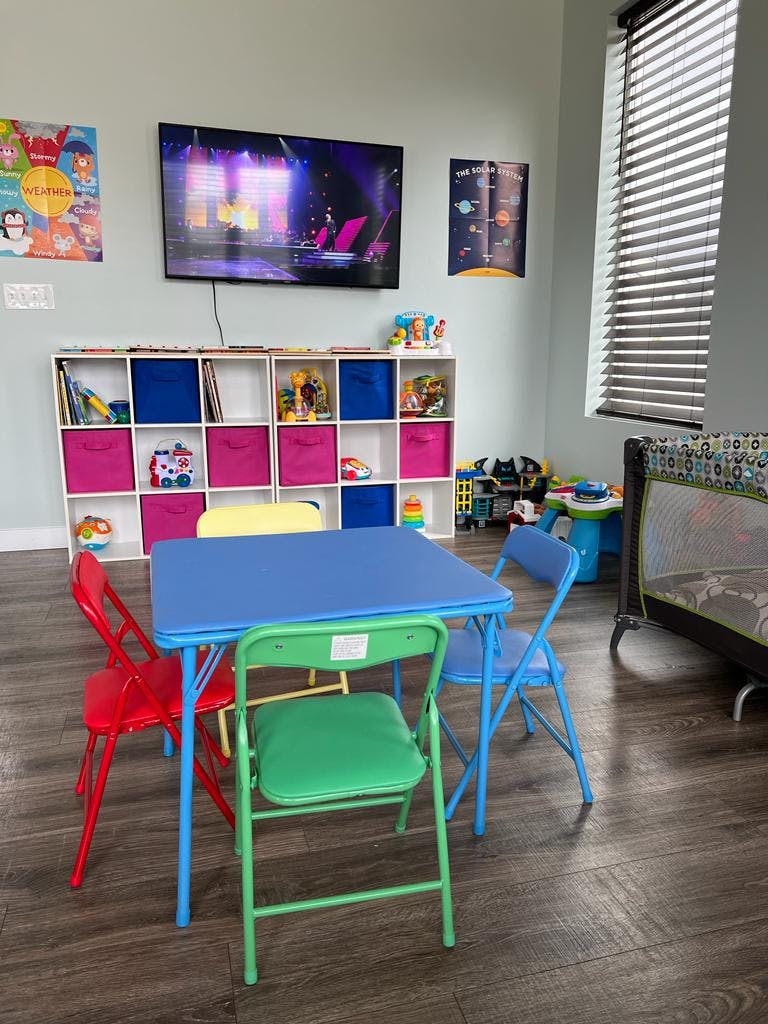 Children's play area with a blue table and colorful chairs
