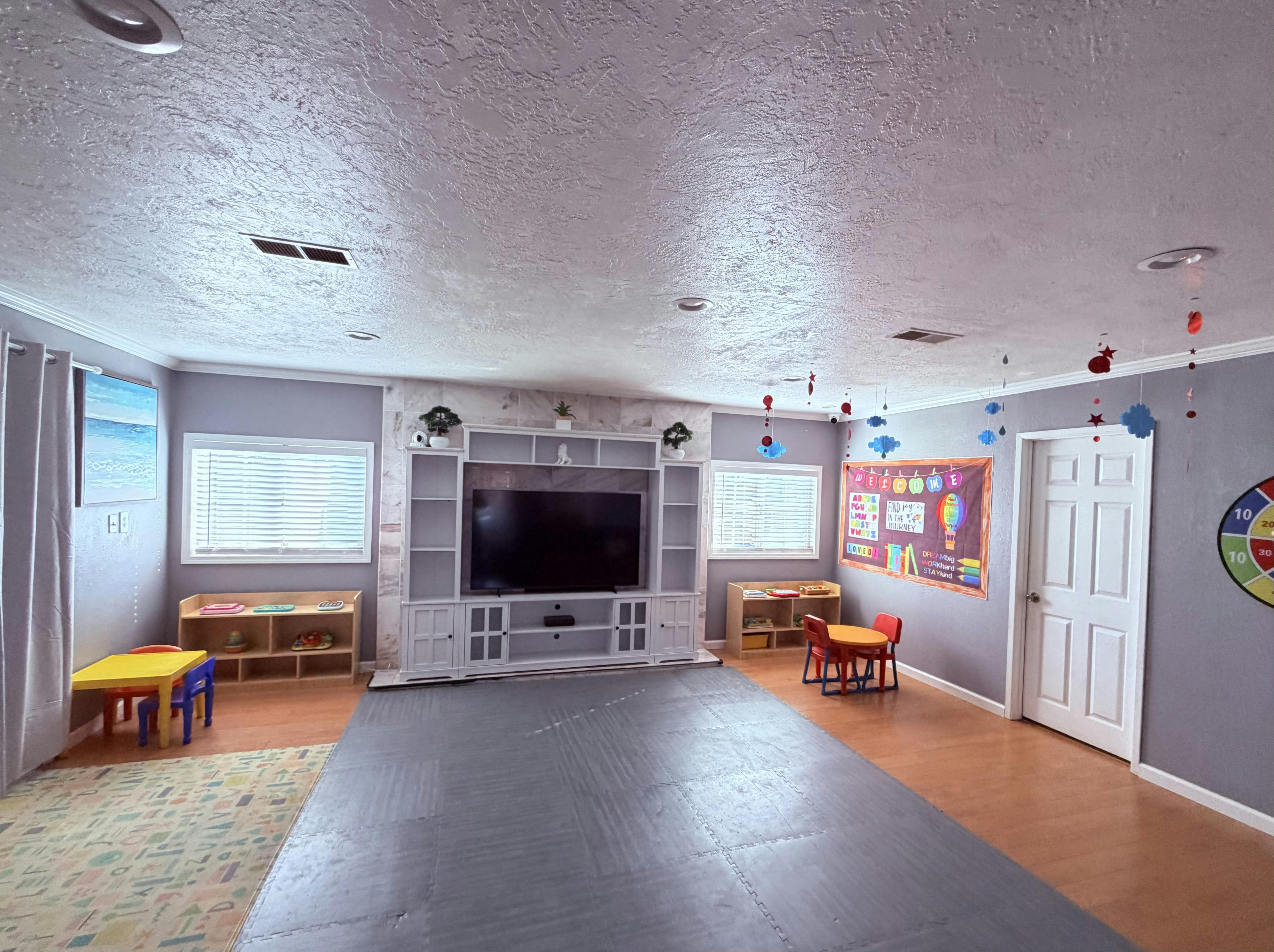 Childrens playroom with toy shelves and small tables