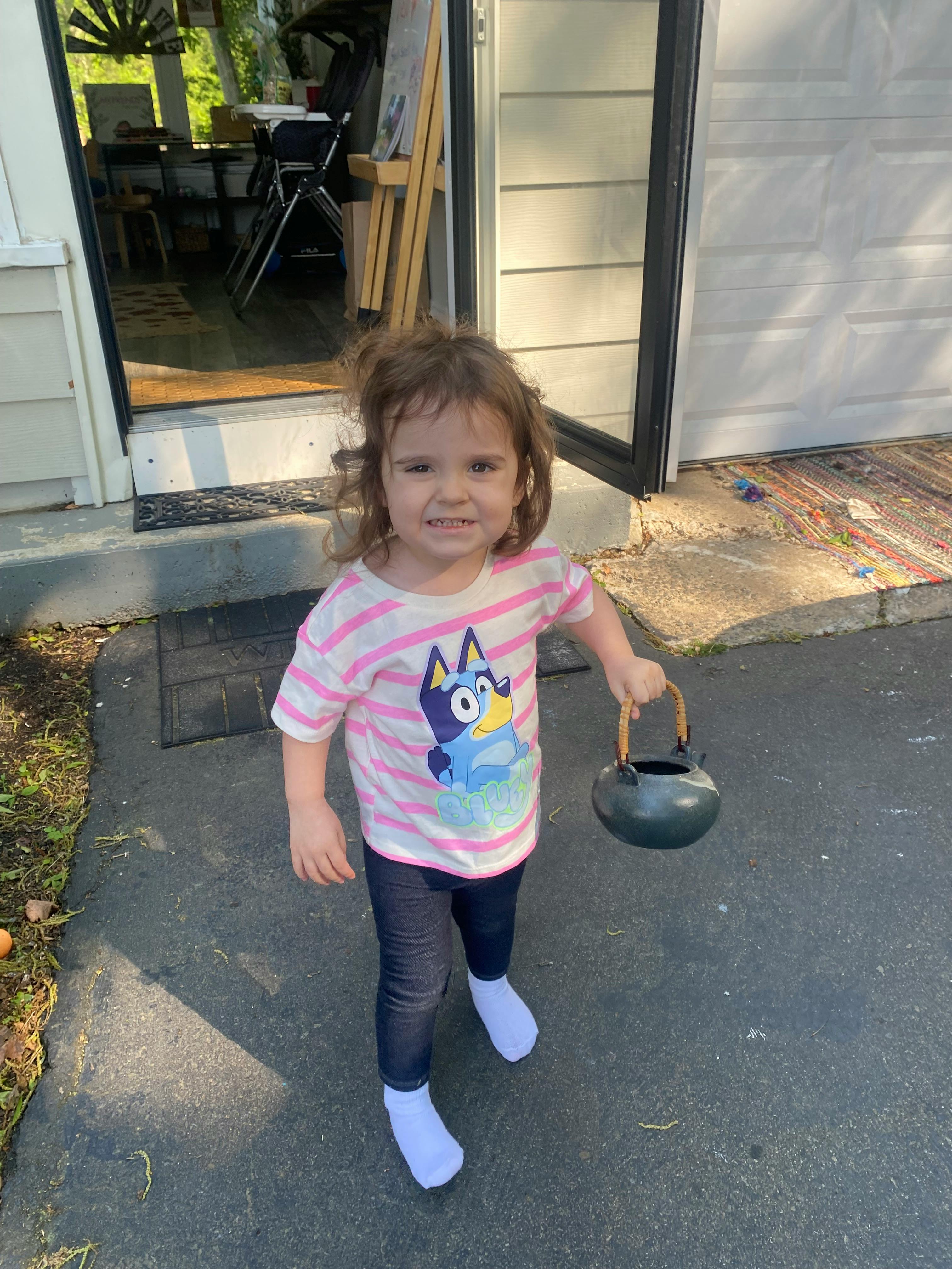 Child holding a small black kettle