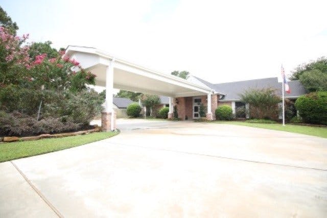 Building with a covered driveway entrance and landscaping