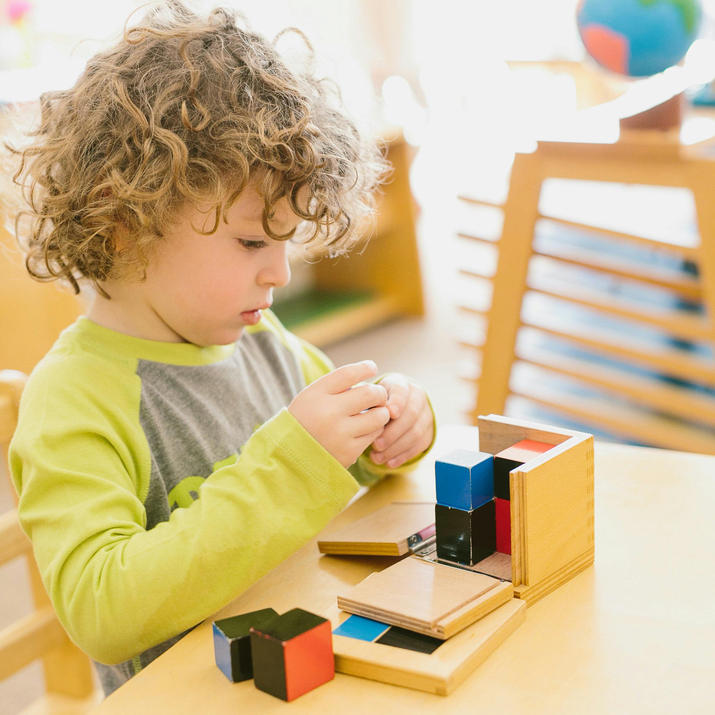 Child playing with wooden blocks at a table