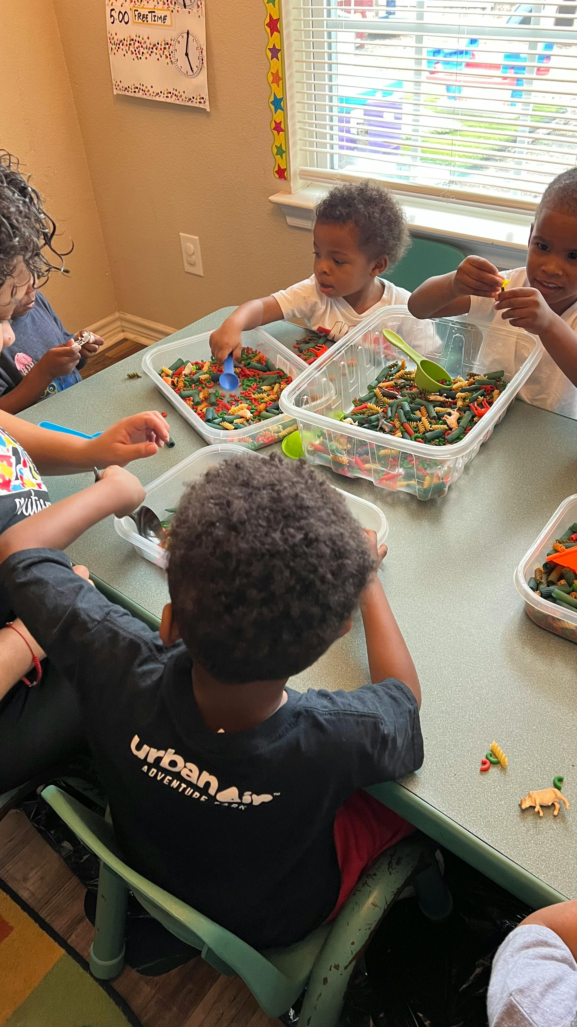 Children playing with sensory bins at a table