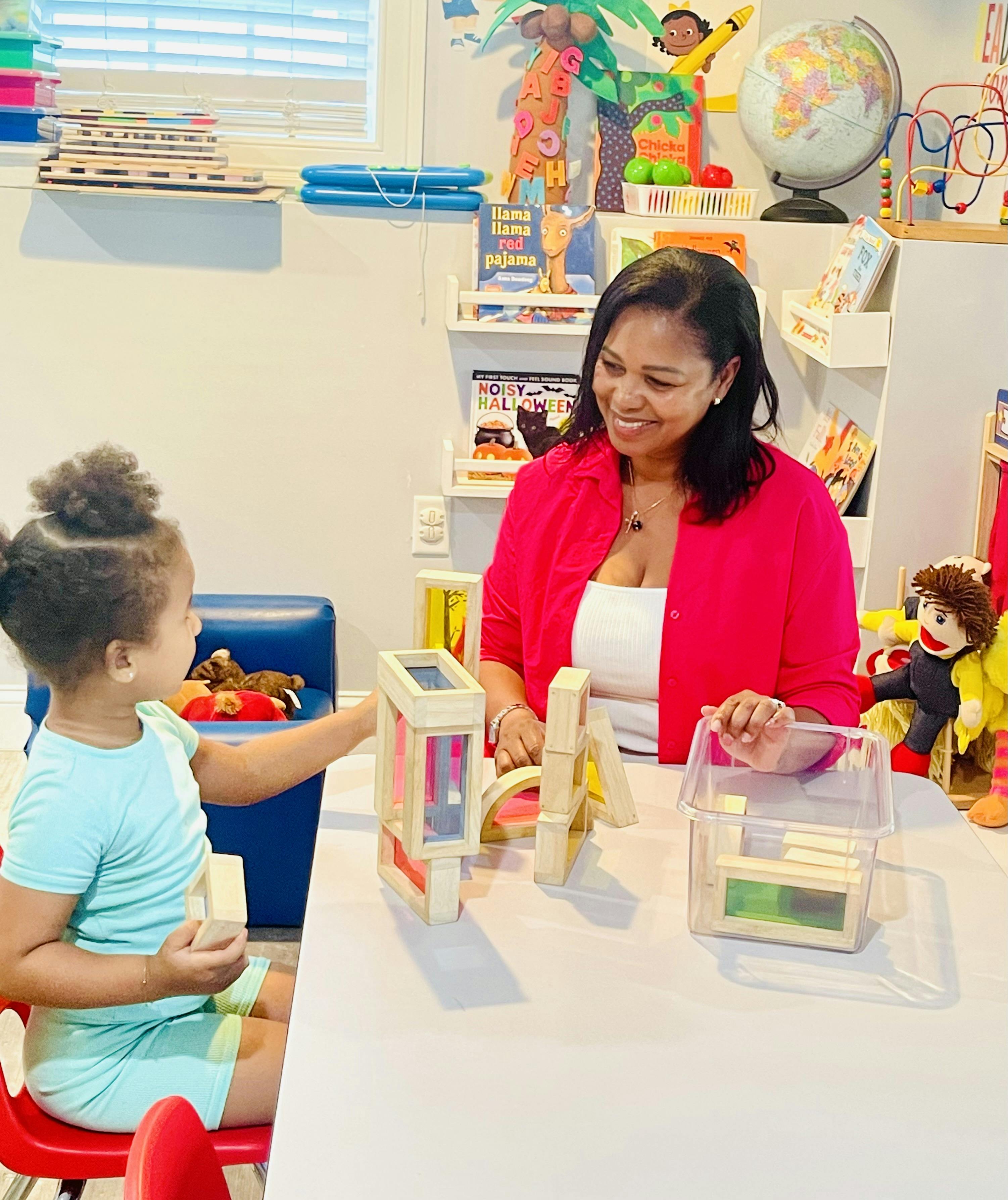 Adult and child playing with blocks at a table