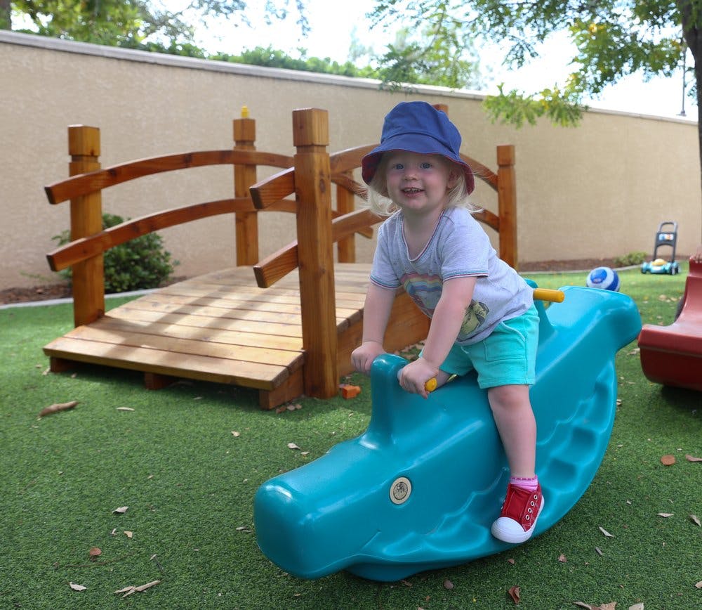 Child on a blue rocking toy in a playground