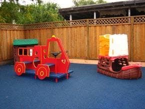 Red toy truck and boat on a blue playground surface