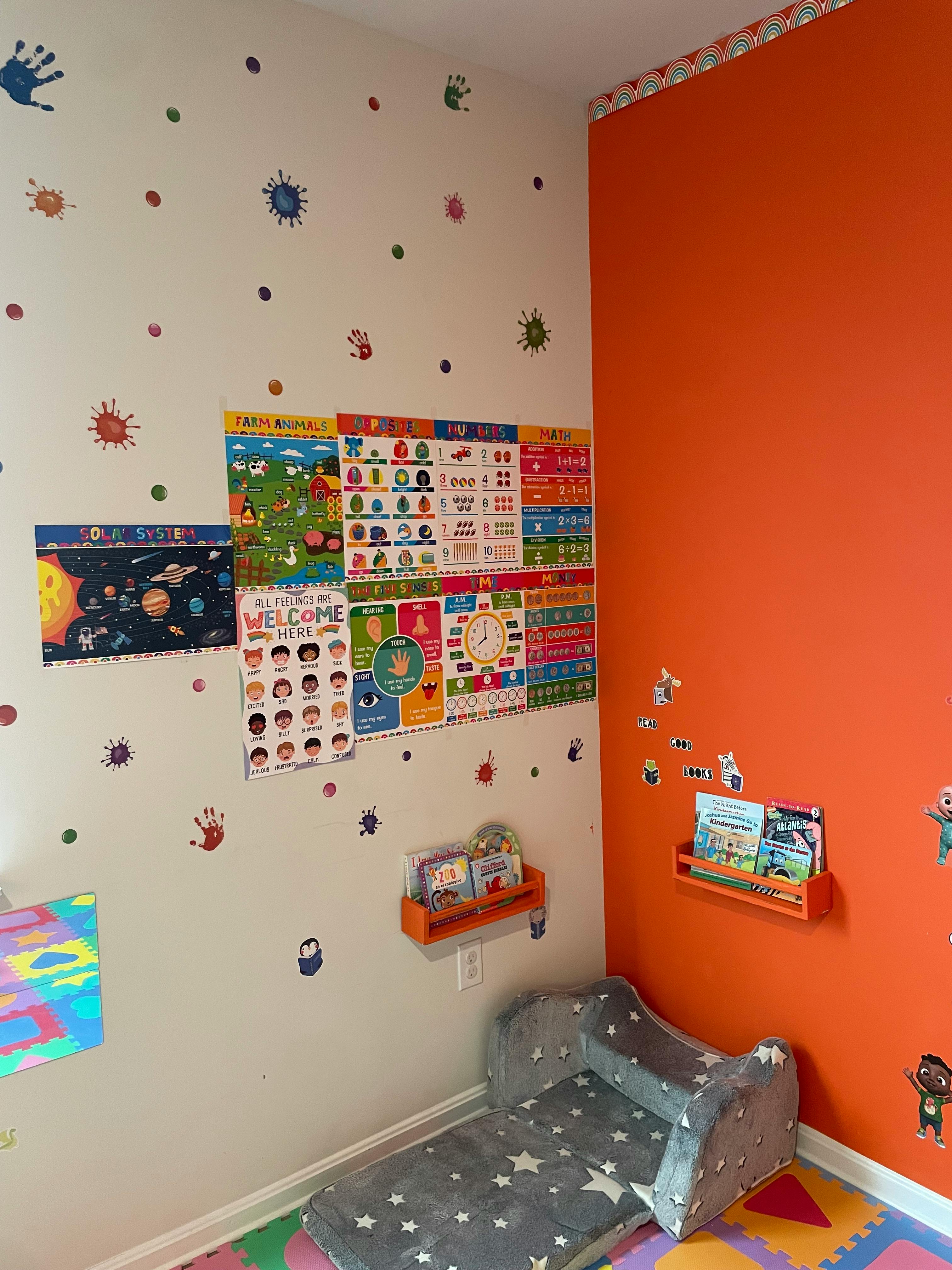 A child's room with educational posters, wall decals, and a small bed