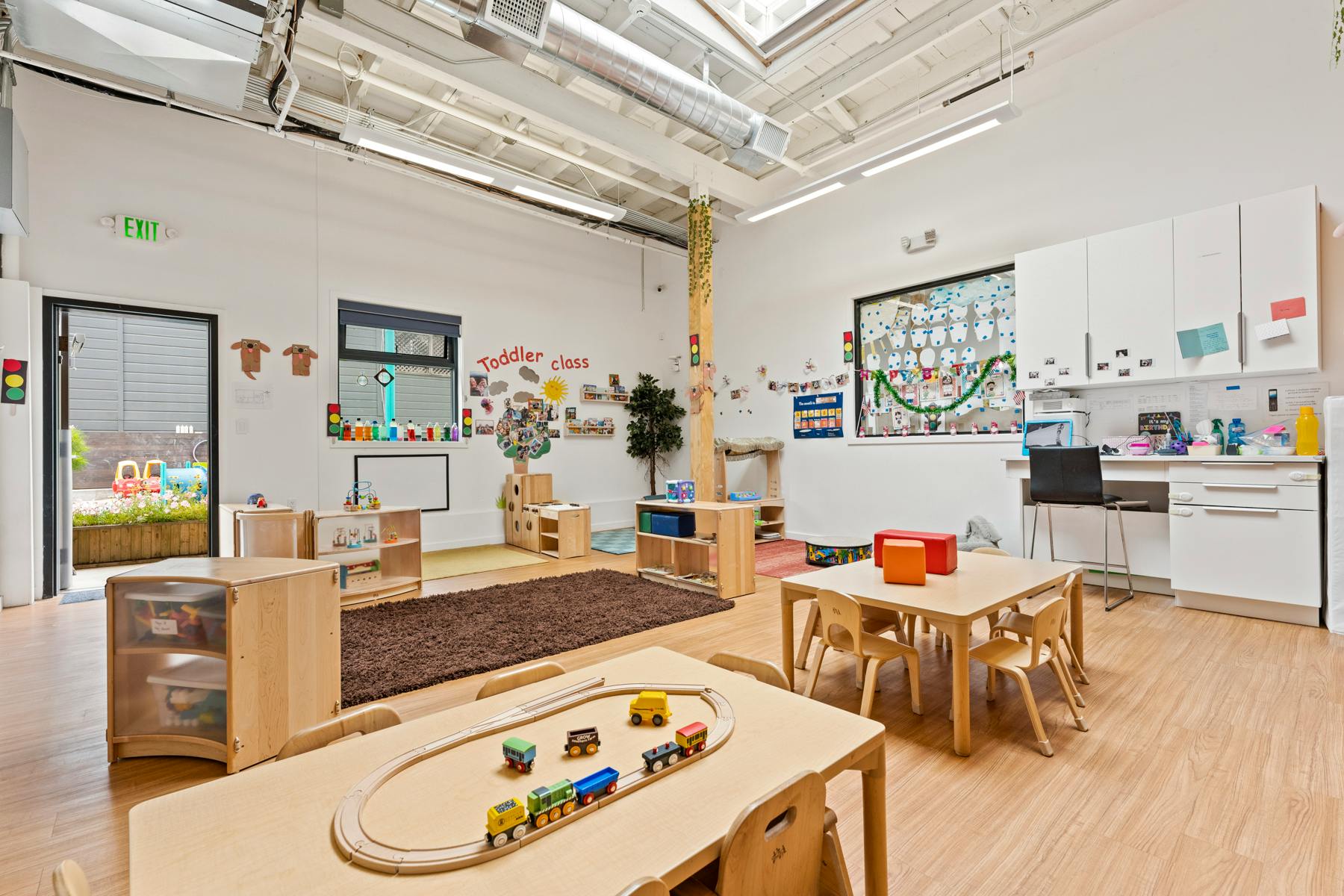 Classroom with tables, chairs, and a toy train set