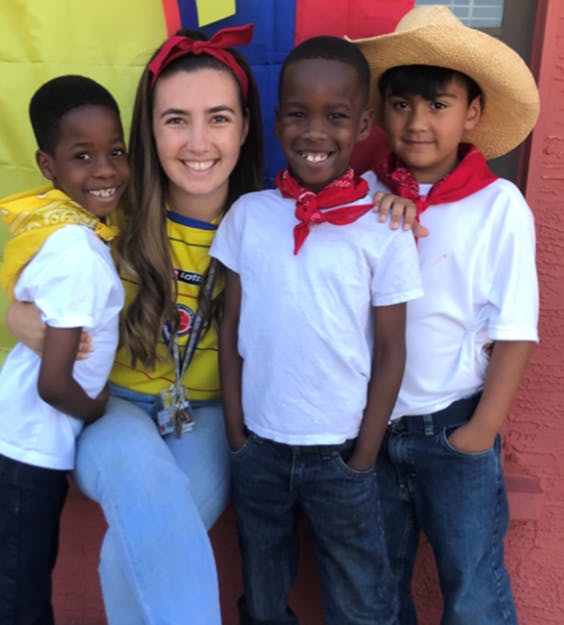 Person with three children standing together