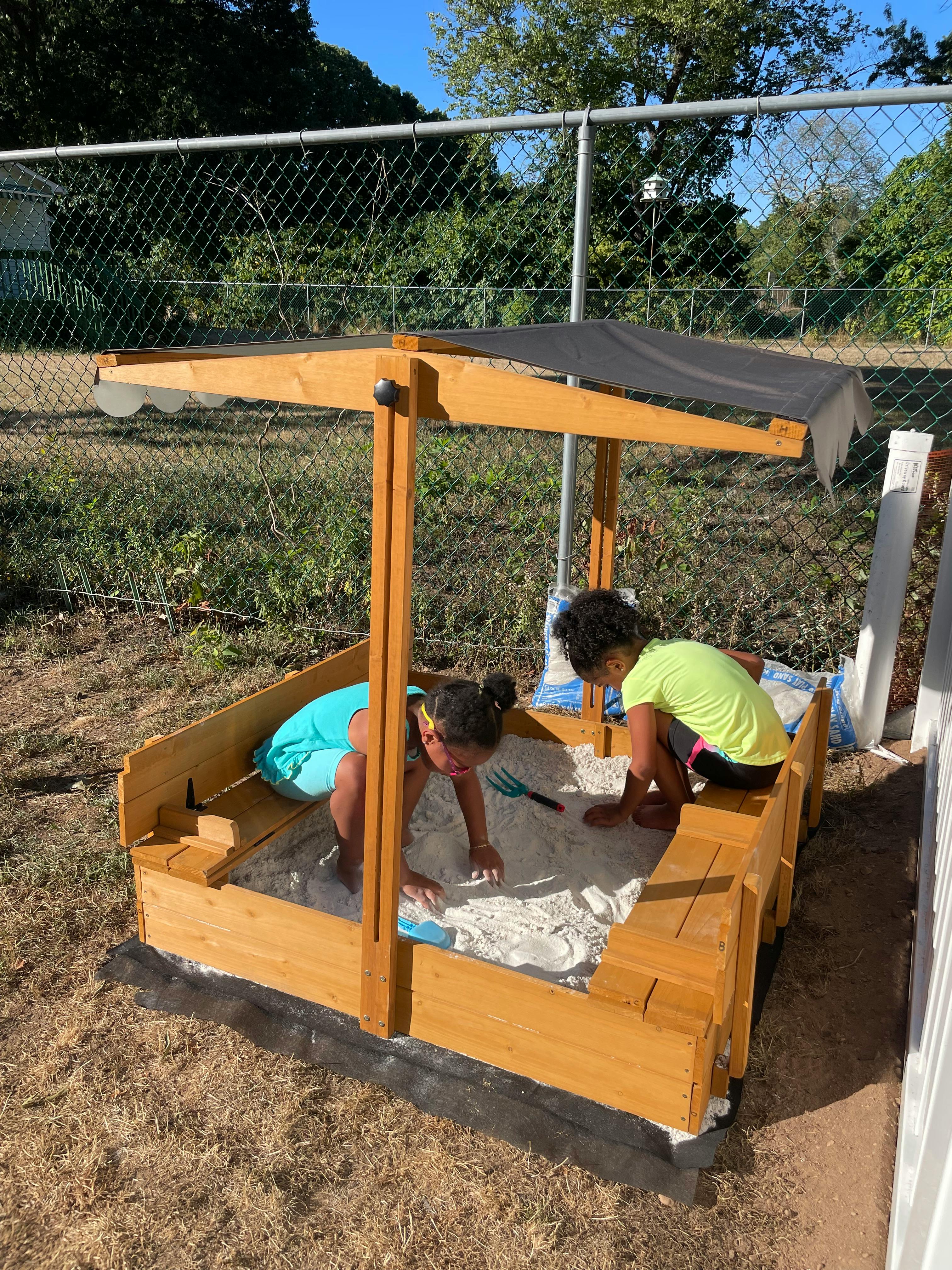 Two children playing in a sandbox
