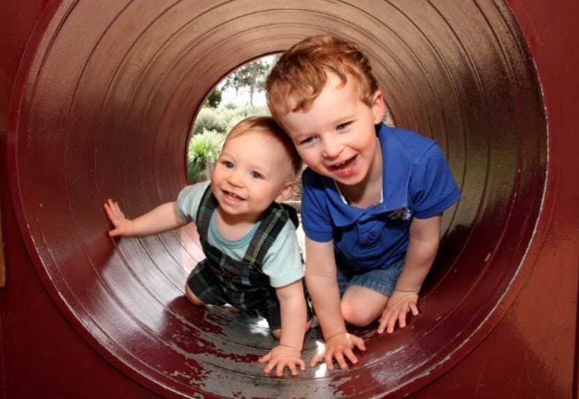 Two children crawling in a tunnel