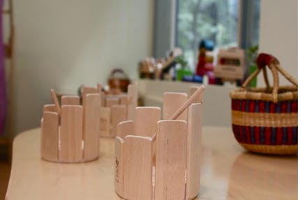 Wooden pencil holders and a woven basket on a table