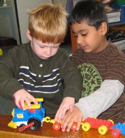 Two children playing with toy trains