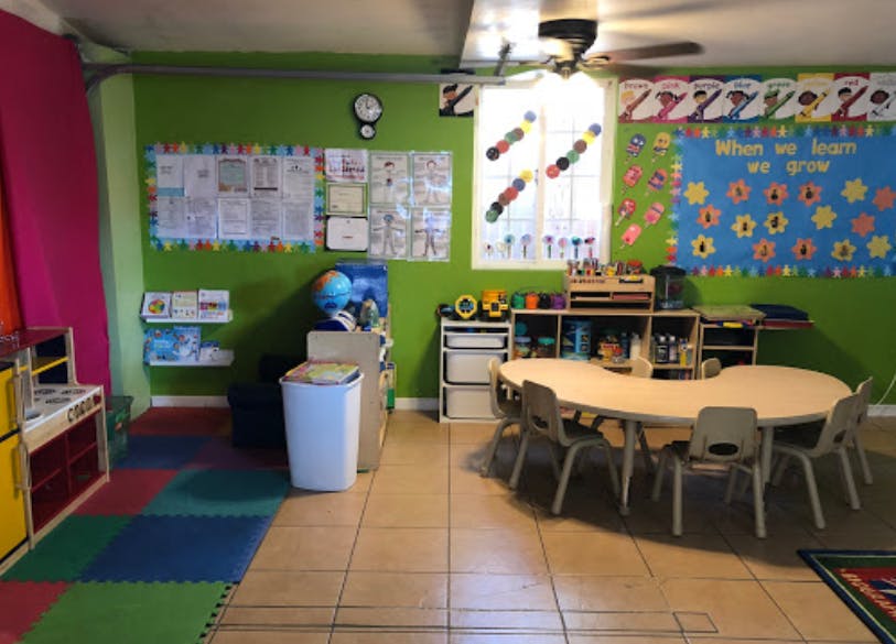 Classroom with small tables and chairs, colorful walls, and educational posters