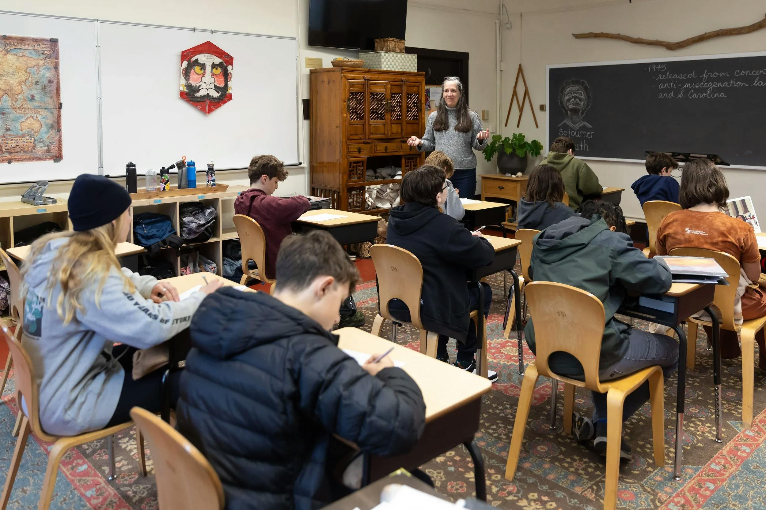 adult leading a classroom of teens seated at desks