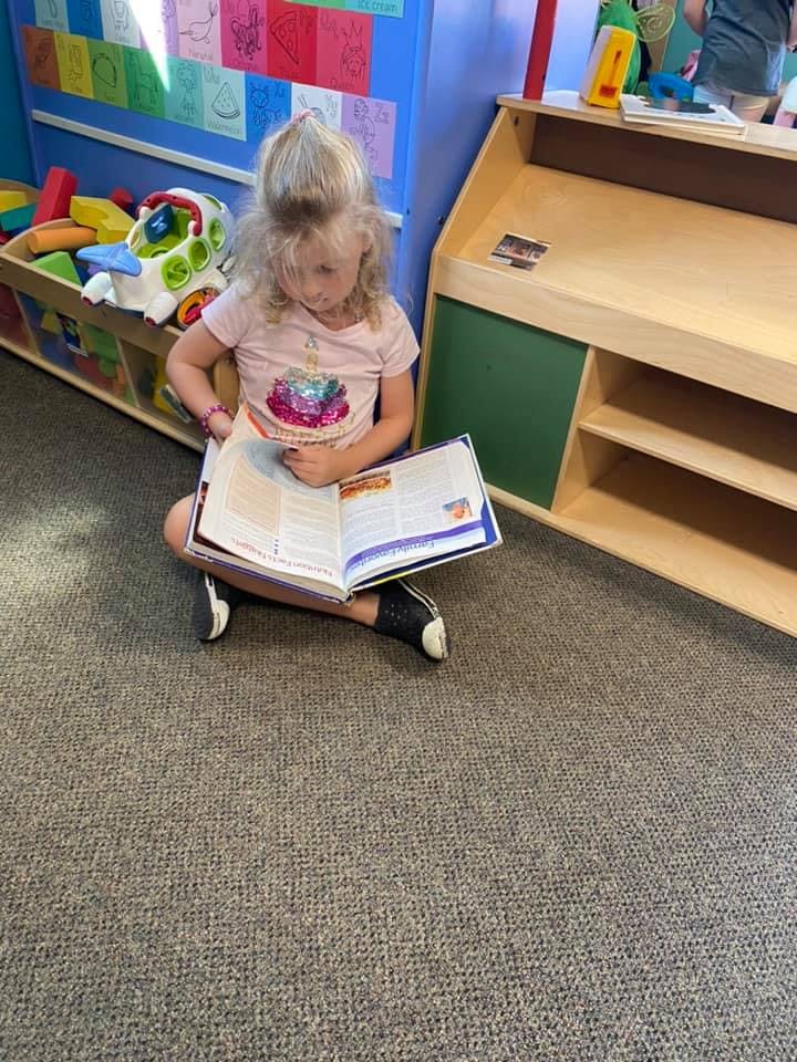 Child sitting on the floor reading a book