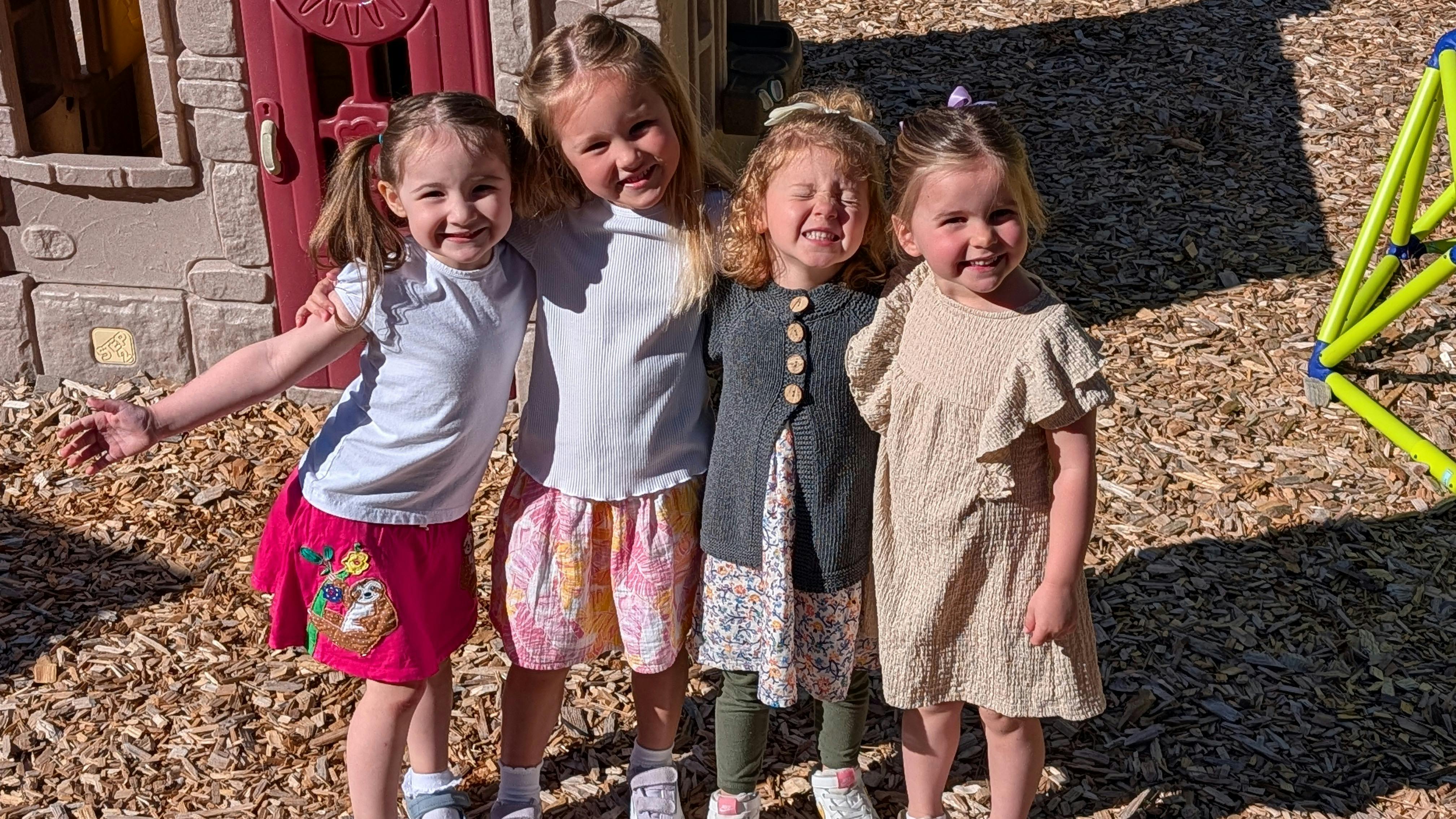 Four children standing together at a playground