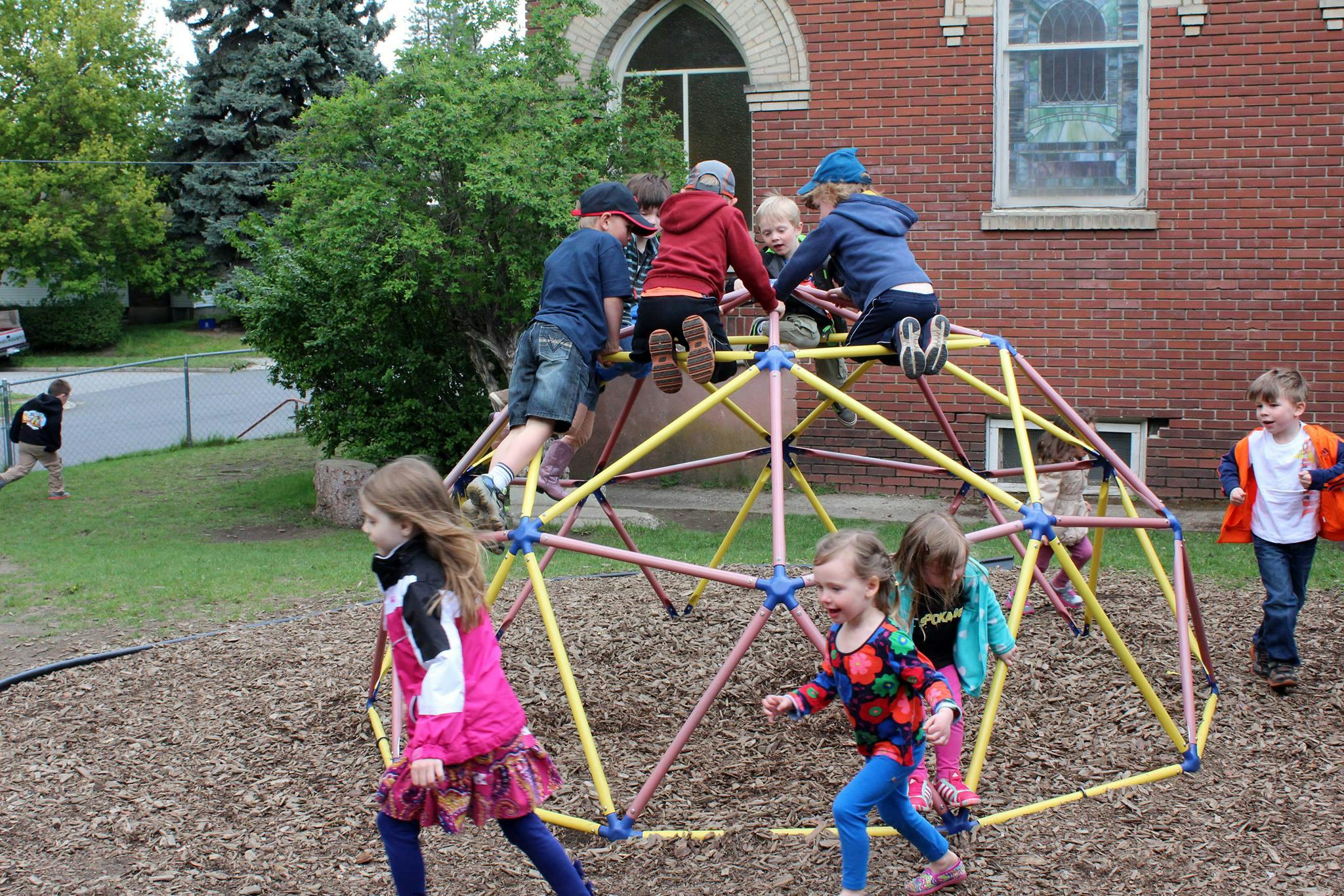 Children playing on a geometric dome climber on a playground