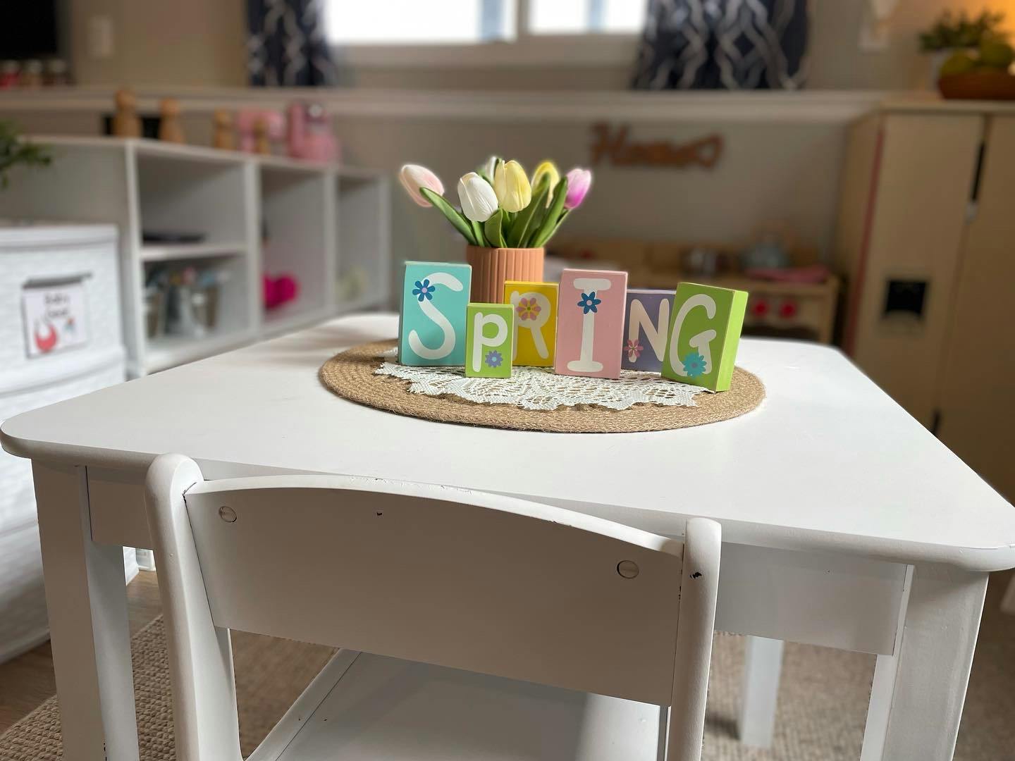 Table with a vase of tulips and blocks spelling SPRING