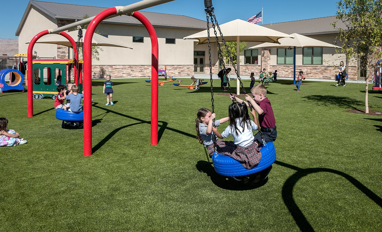 Children playing on swings and playground equipment