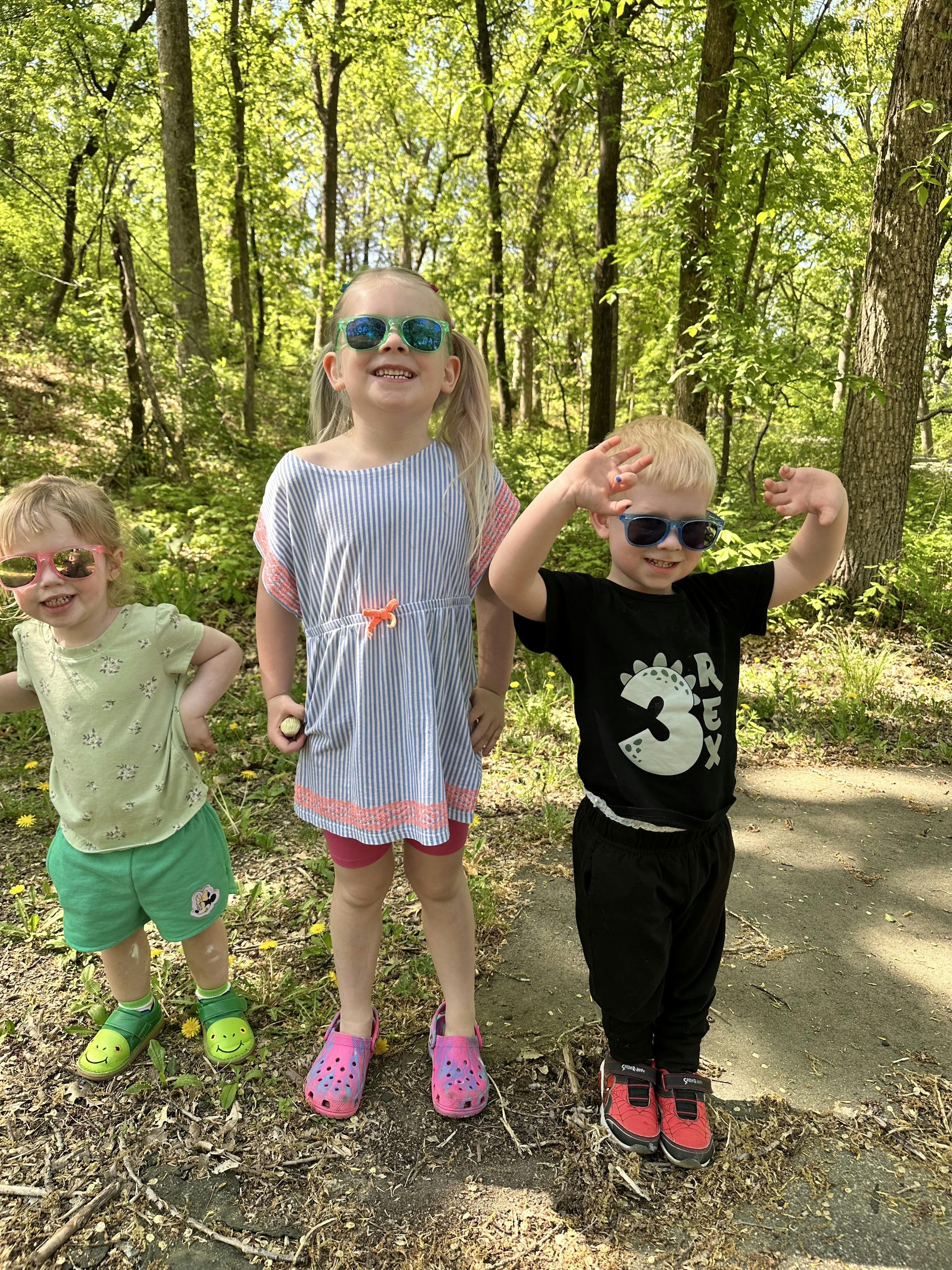 Three children in sunglasses posing outdoors