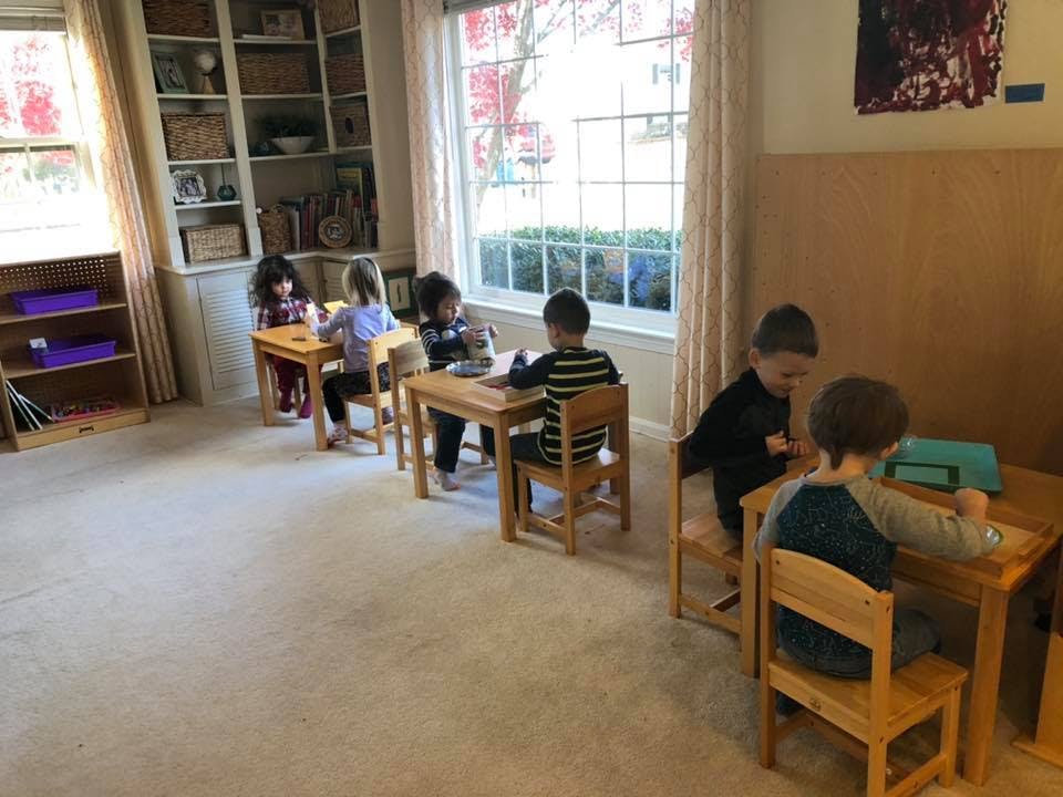 Children sitting at small wooden desks in a classroom