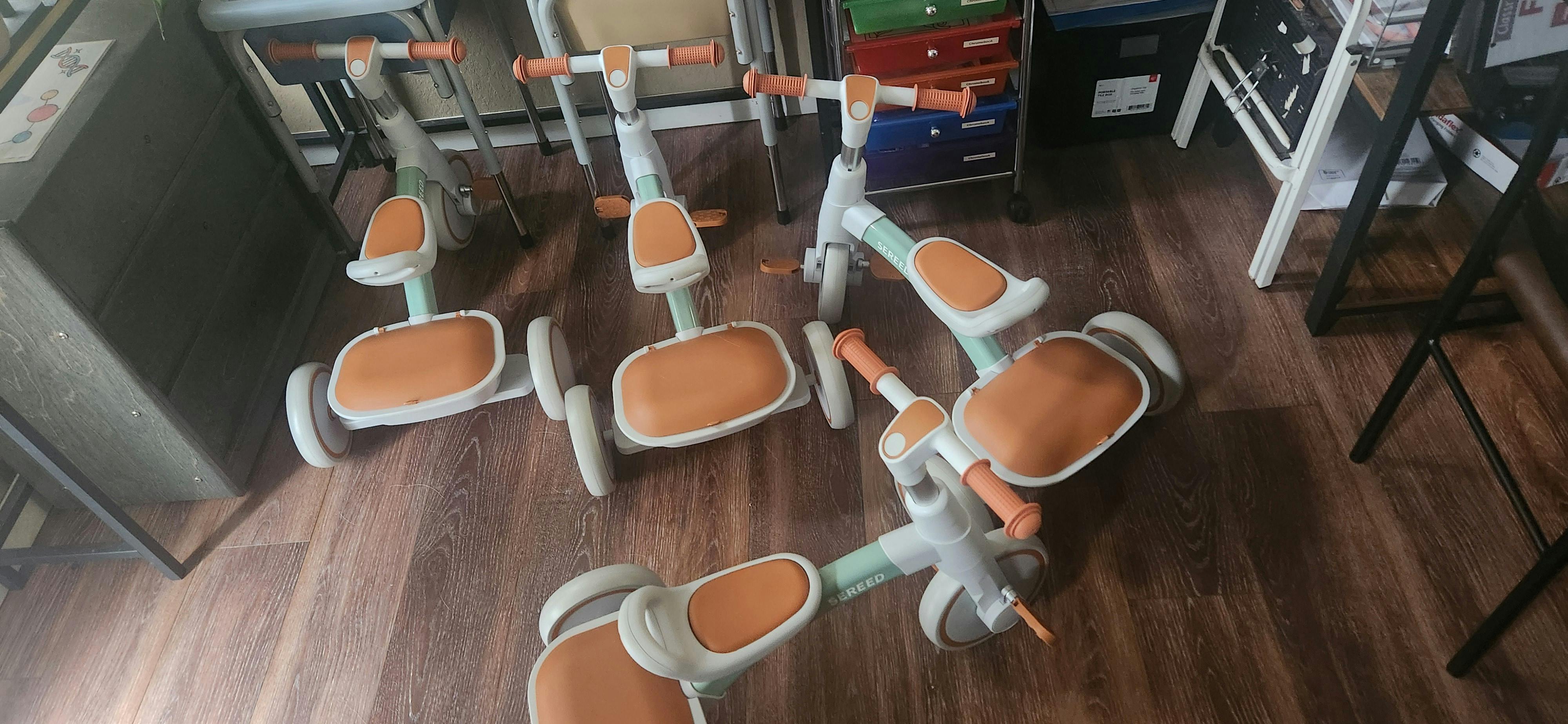 Multiple small ride-on toys with seats and handlebars