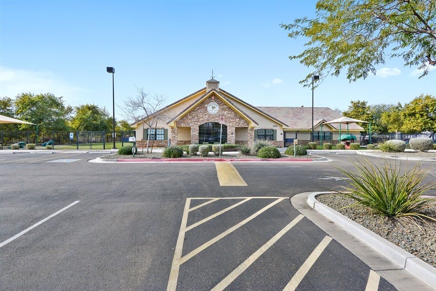 Building with a stone facade and a parking lot in front