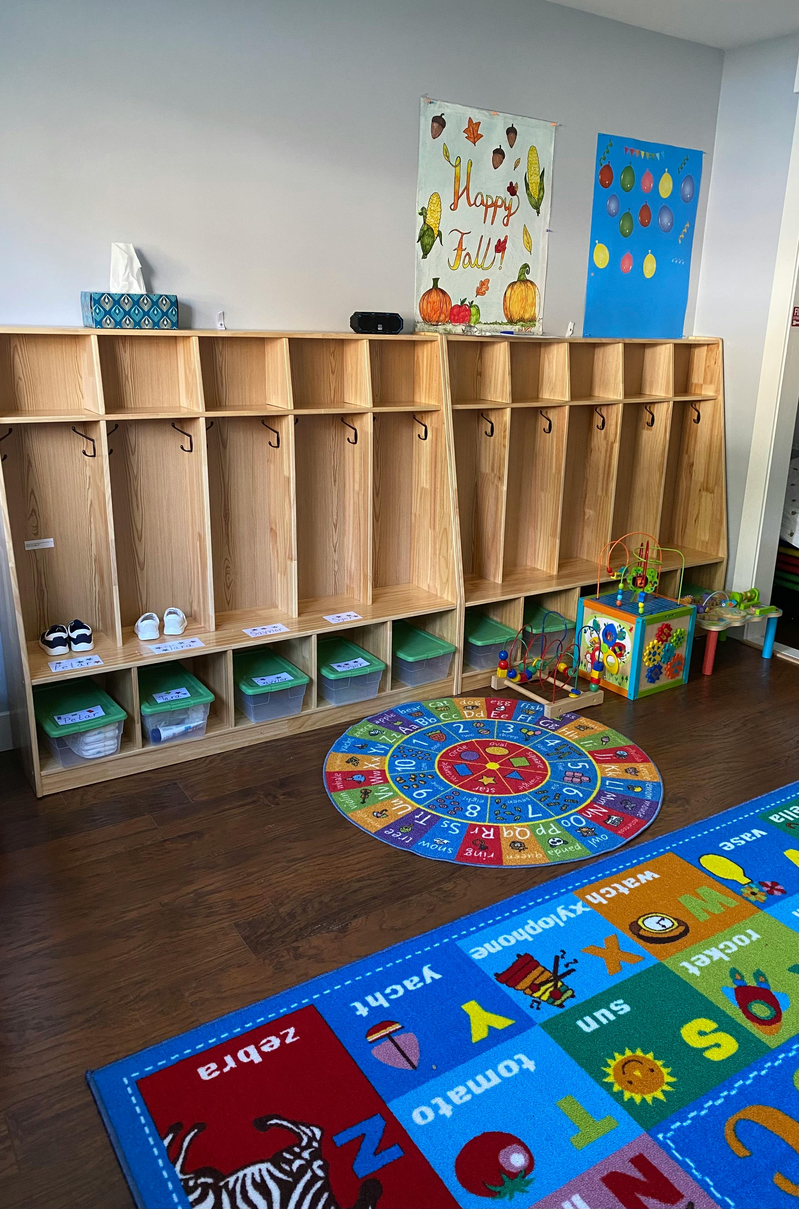 Classroom with wooden cubbies, colorful rugs, and toys