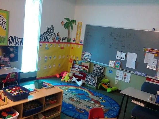 Classroom with a chalkboard, colorful rug, and toys