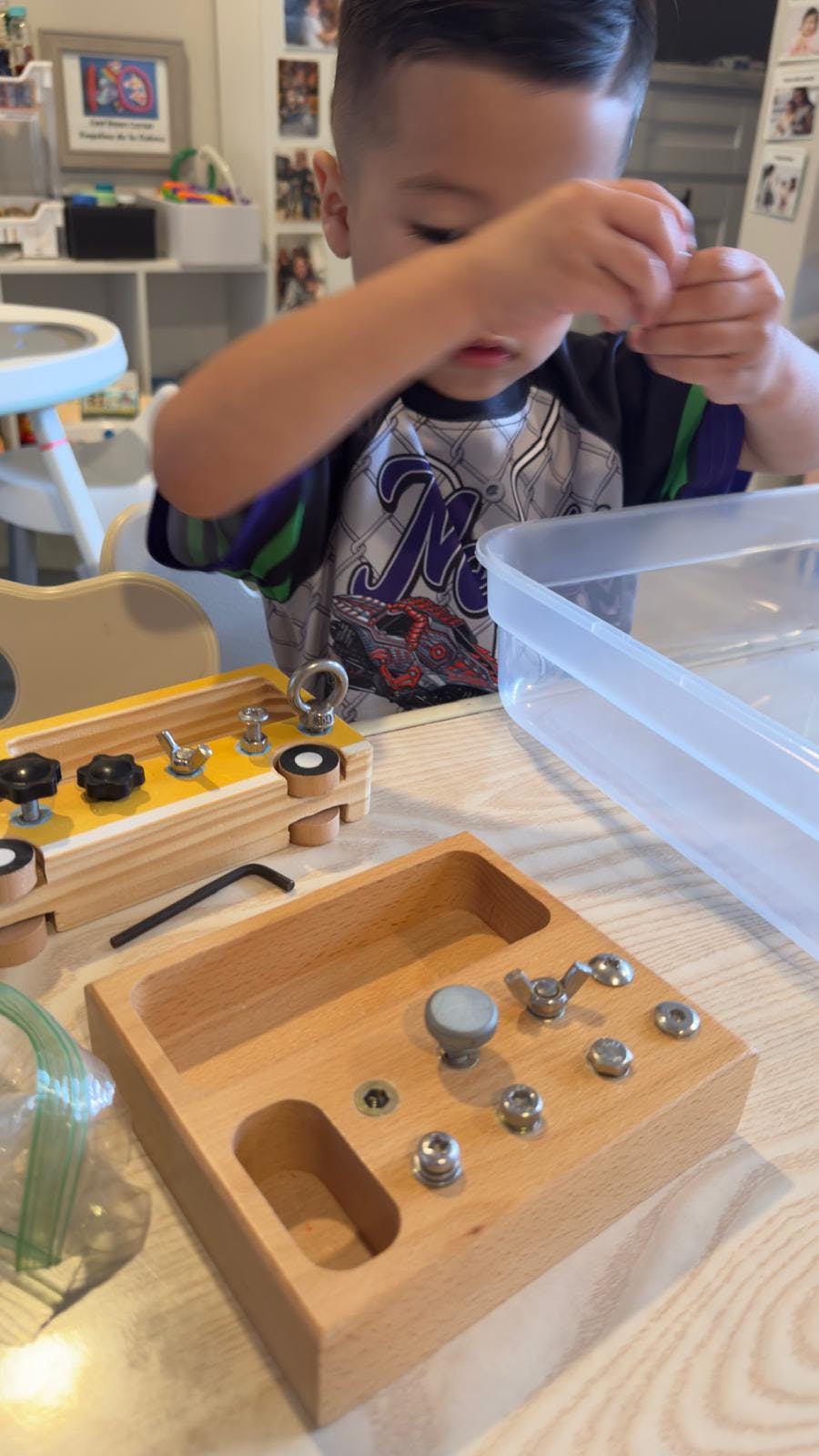 Child manipulating parts of a wooden learning board