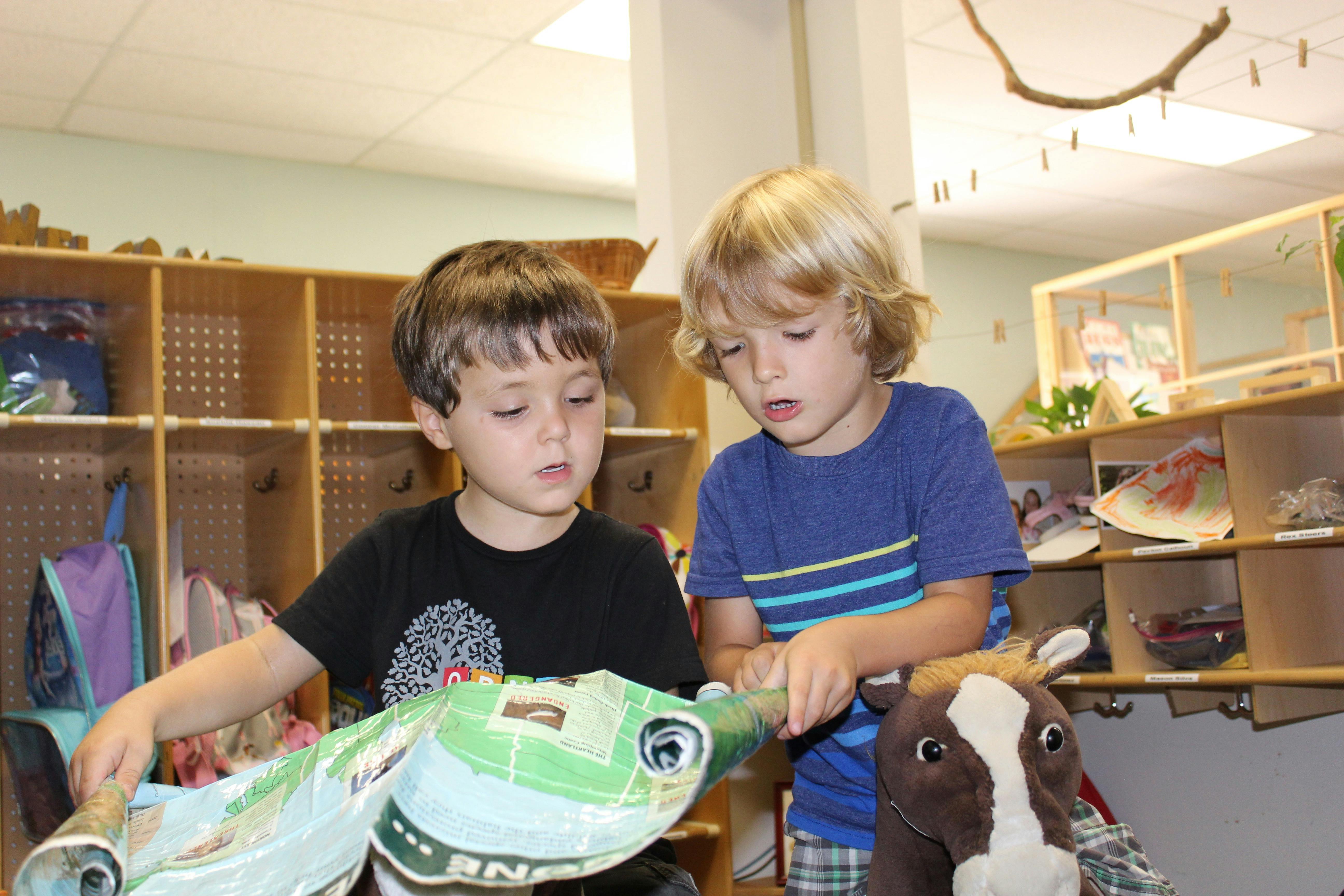Two children playing with a toy in a classroom