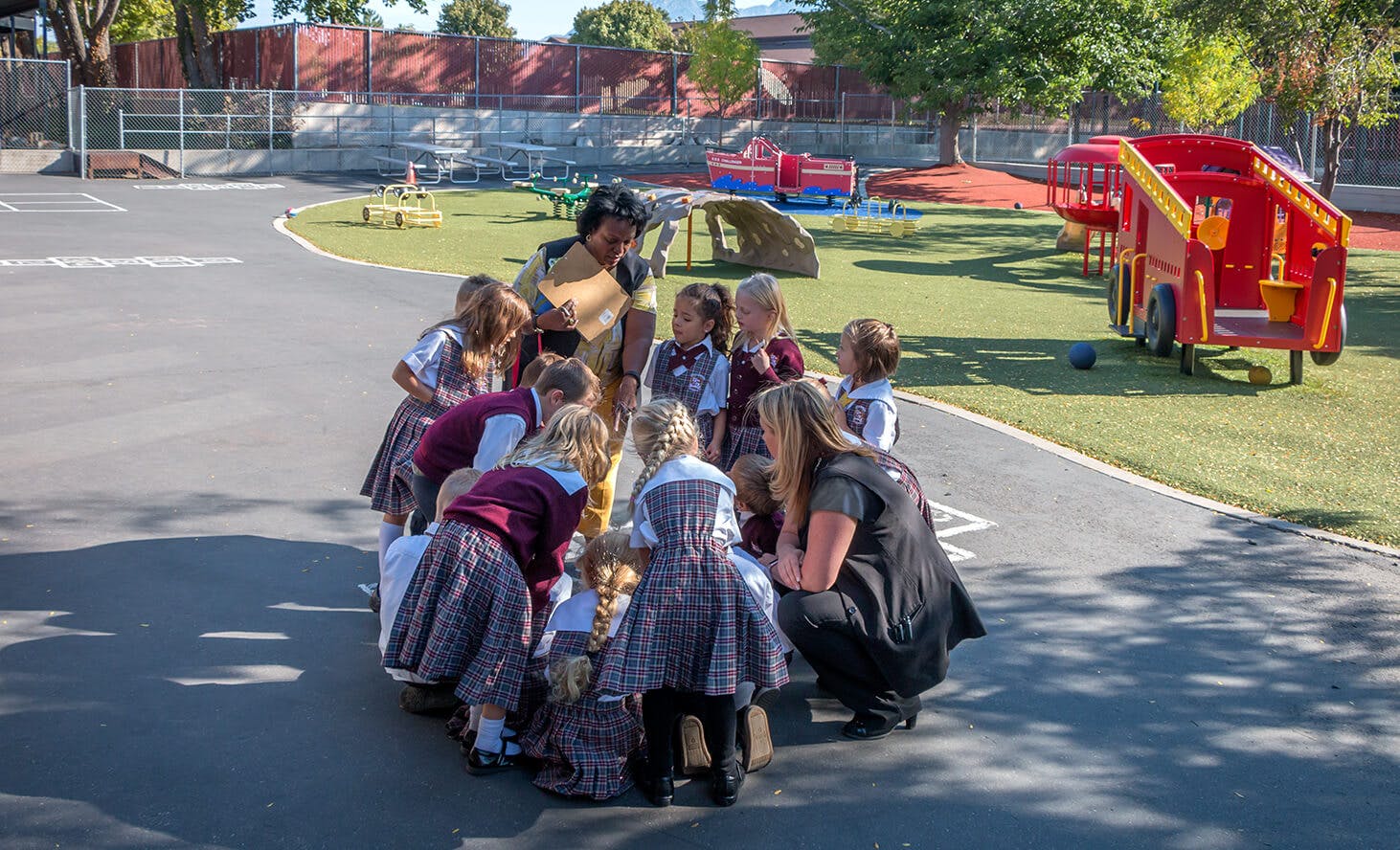 Adults and children gathered in a circle on a playground