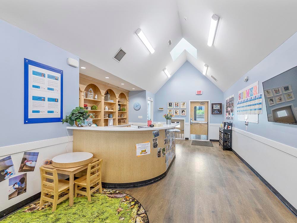 Reception area of a daycare or preschool with a curved desk and small table