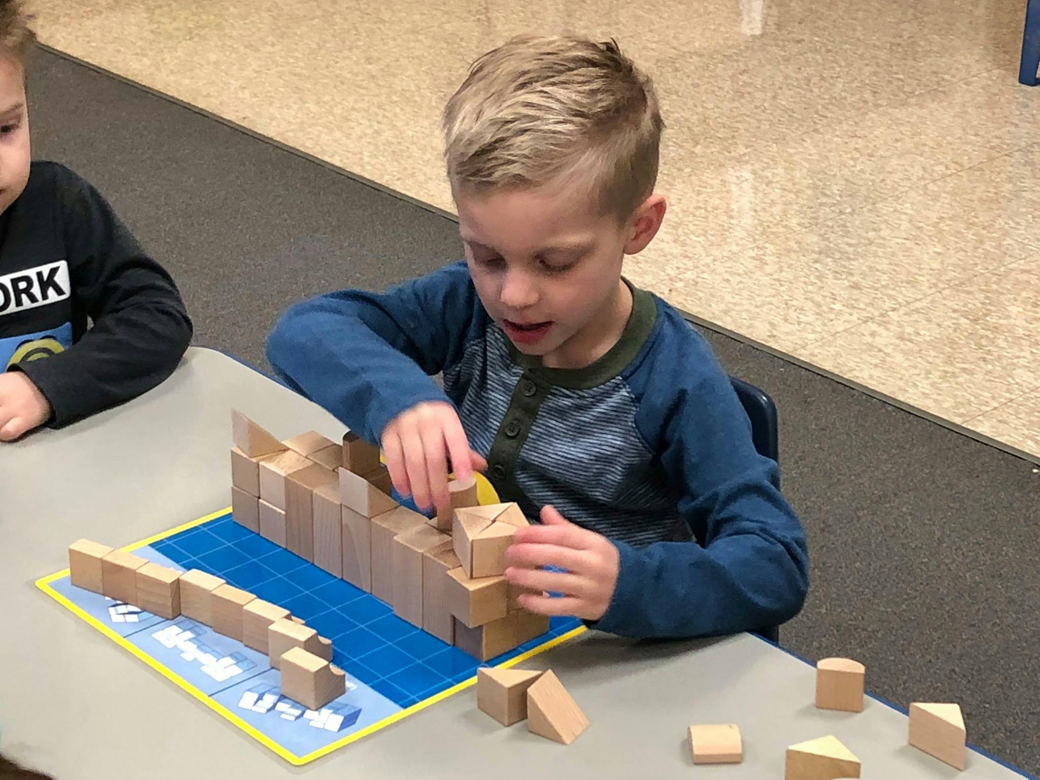 Child building with wooden blocks at a table