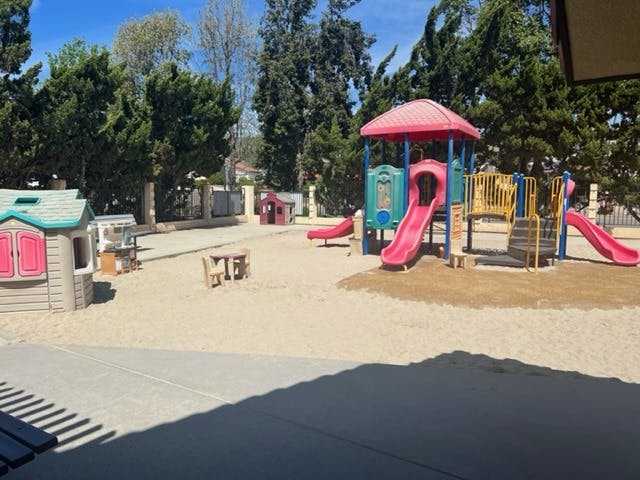 Playground with slides and playhouses on a sandy surface