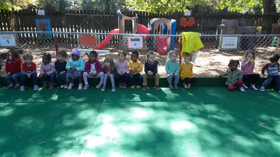 Group of children sitting in a row outdoors