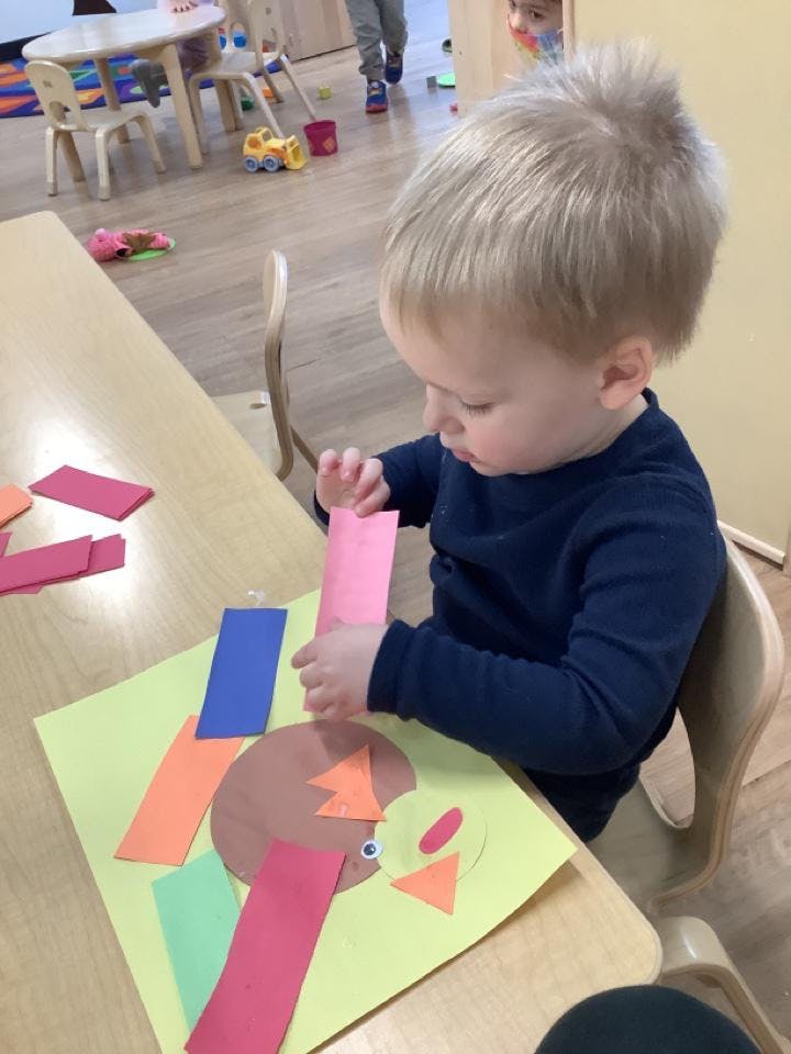 Child doing a paper craft at a table