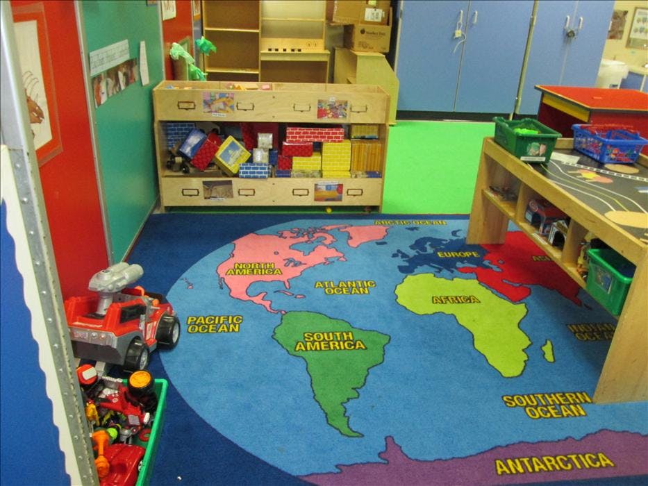 Classroom with a world map rug on the floor and toy storage