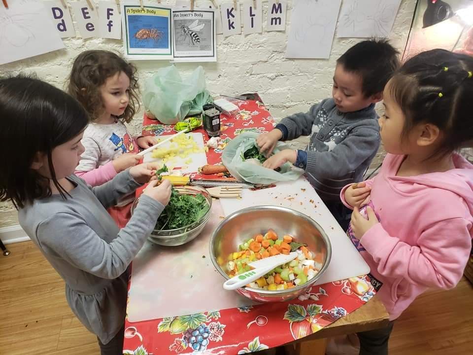 Children preparing food at a table