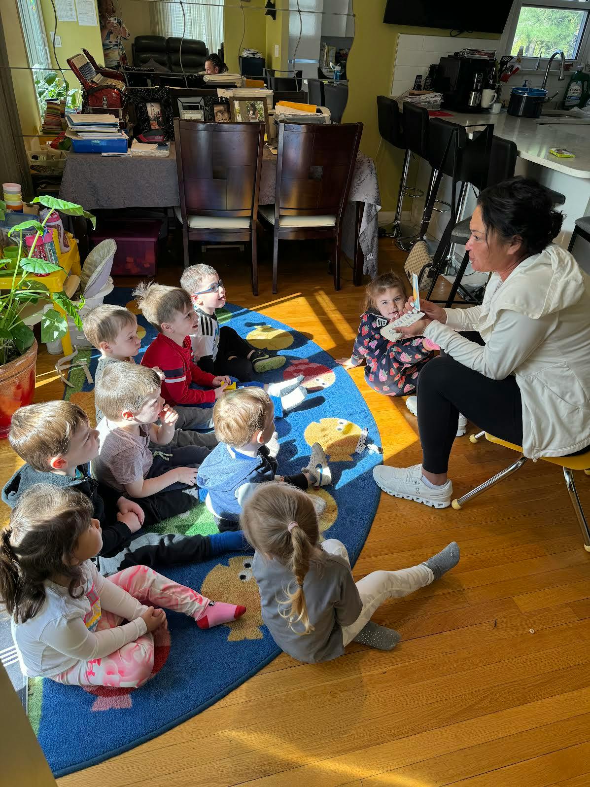 Adult reading to a group of children sitting on a rug