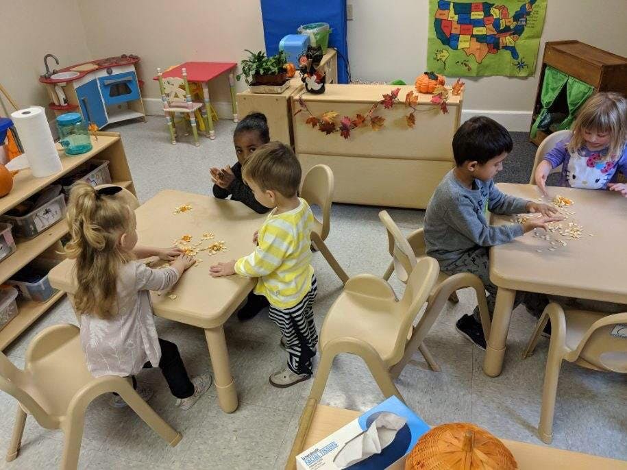 Children playing at tables in a classroom