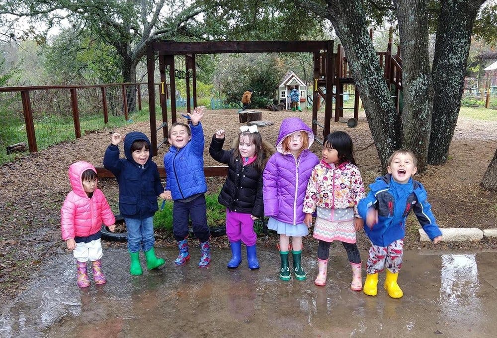 Group of children in rain gear standing outdoors